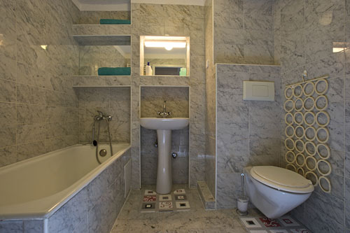 The first bathroom has a bath tube and a toilet. It´s door opens to the corridor connecting the kitchen with the terrace. 