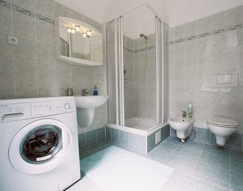 
Another view of the main bathroom in Spanelska apartment, with washing machine, shower, bidet and toilet.